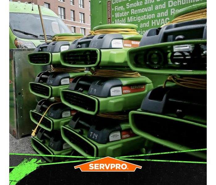 A massive amount of SERVPRO equipment stacked in front of a SERVPRO truck.